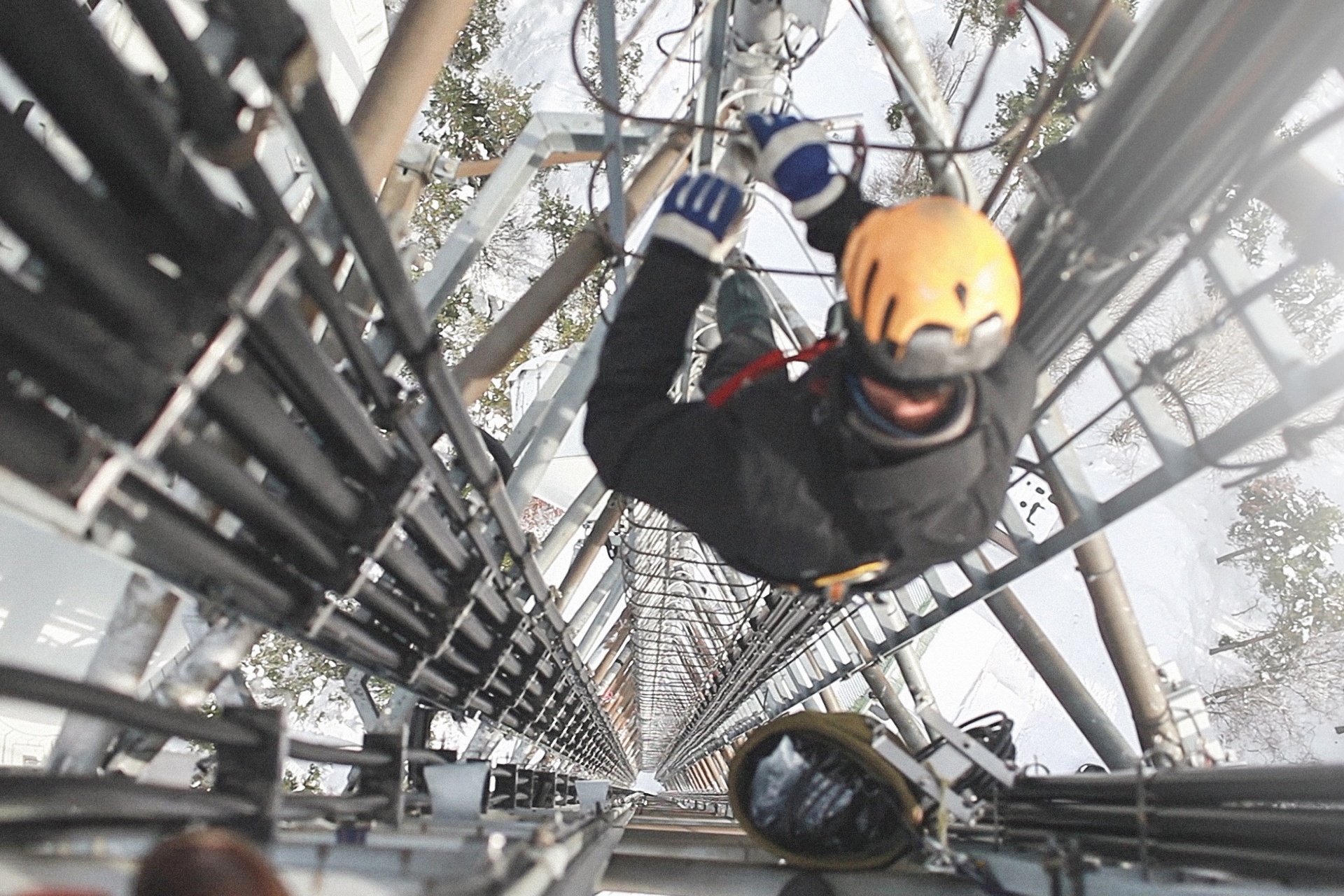 An image of a construction worker climbing the phone tower