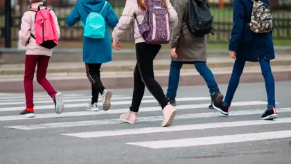 Students walking across the street Students walking across the street