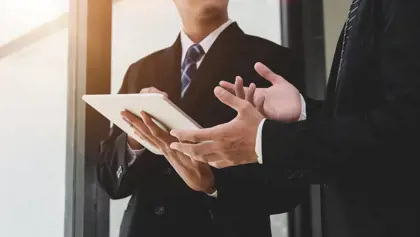Businesspeople discussing information displayed on a tablet Businesspeople discussing information displayed on a tablet