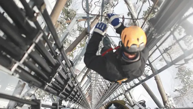 An image of a construction worker climbing the phone tower An image of a construction worker climbing the phone tower