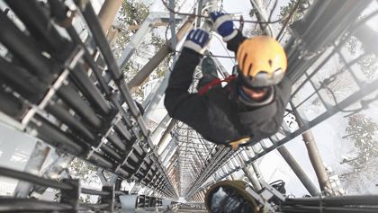 An image of a construction worker climbing the phone tower