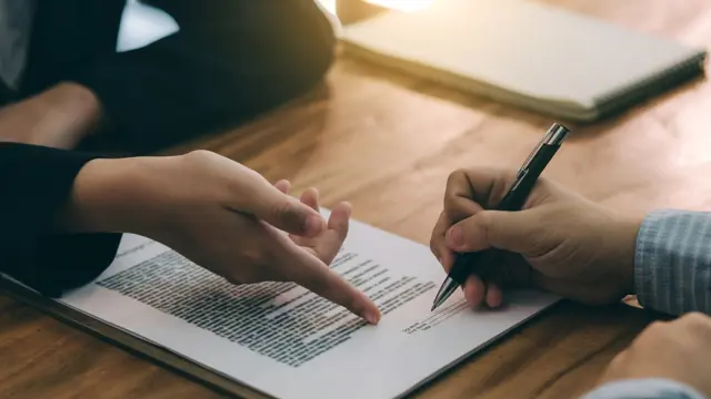 Two hands pointing towards a document Two hands pointing towards a document