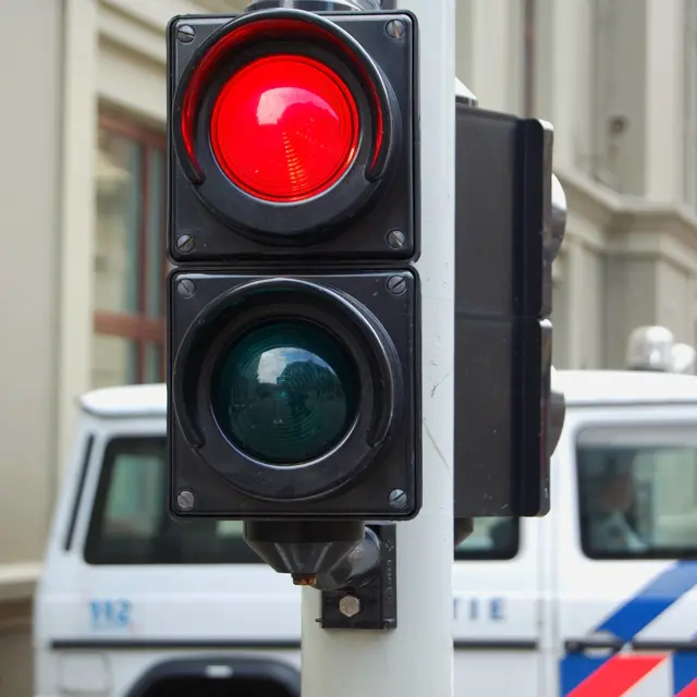 An image of a traffic light showing red colour on the street An image of a traffic light showing red colour on the street