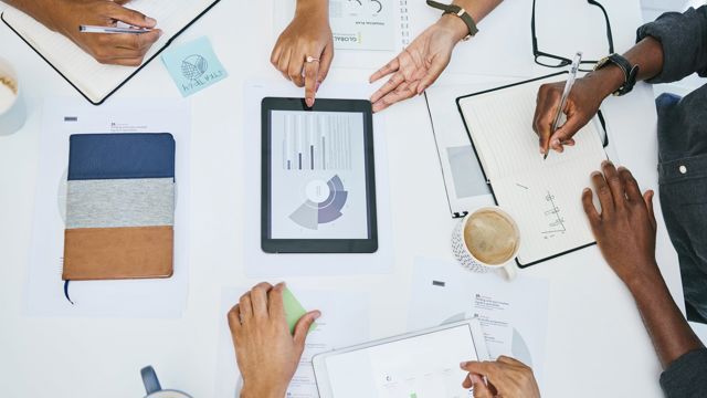 Four people working around a table collaborating on a business value assessment