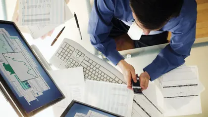 Person working at a desk and using technology Person working at a desk and using technology