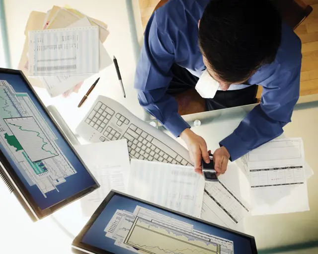 Person working at a desk and using technology Person working at a desk and using technology