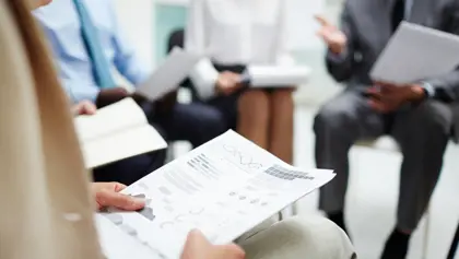 Person holding a document with graphs Person holding a document with graphs