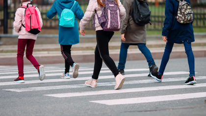 Students walking across the street Students walking across the street